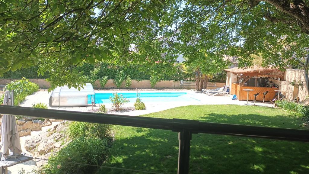 een achtertuin met een zwembad en een hek bij Les dodos de Rose in Doué-la-Fontaine