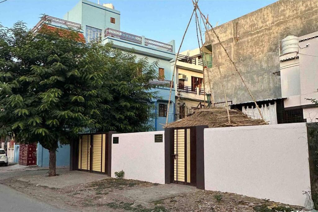 una pared blanca con un árbol al lado de un edificio en Chandrika Residency, en Jhūsi