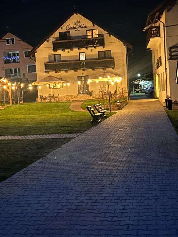 a building with a bench in front of it at night at Casa Mia in Braşov