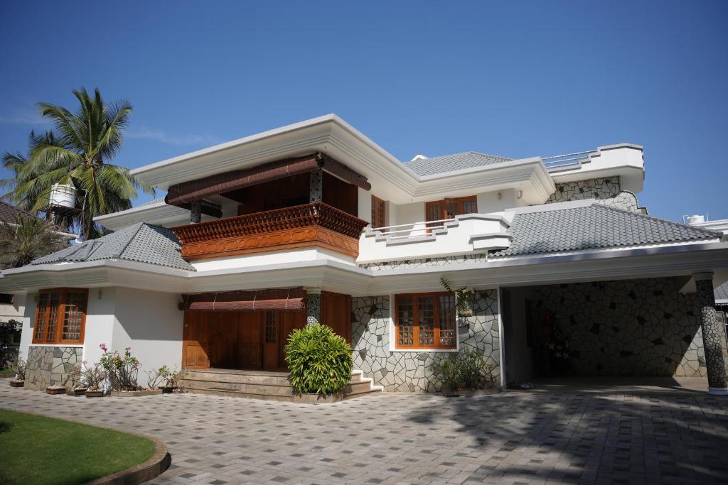 a large white house with a driveway at Alite Posh 4 BHK Villa in Thrissur Town in Trichūr