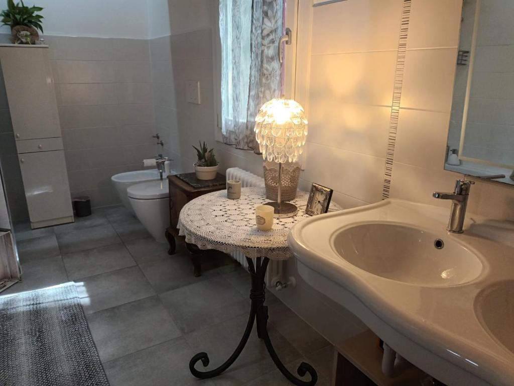 La salle de bains est pourvue d'un lavabo, de toilettes et d'une lampe. dans l'établissement Il melograno, à Vittorio Veneto