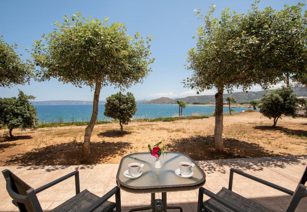 a table with two cups on it next to a beach at Balos Beach in Kissamos