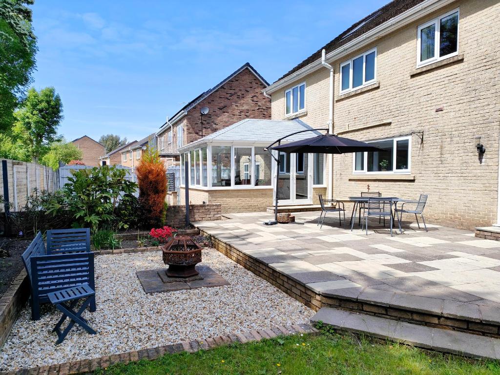 a patio with a table and an umbrella at Sanderson House in Cleator Moor