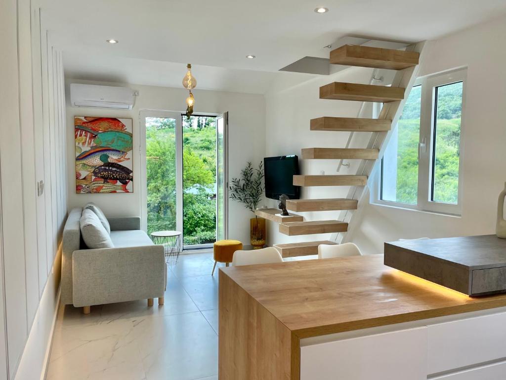 a living room with a staircase with a couch and a tv at Lovely studio apartment near Porto Novi marina in Herceg-Novi