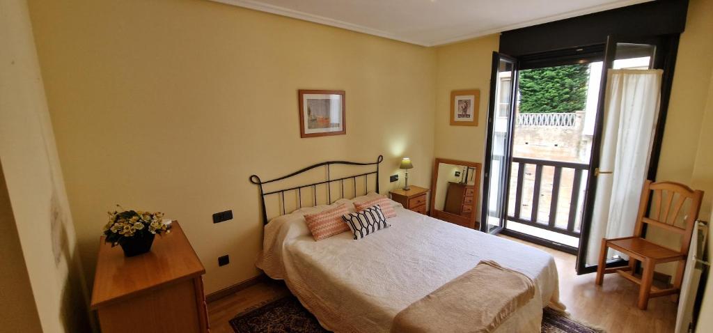 1 dormitorio con 1 cama y balcón en Raitán 2 - Apartamento con piscina para 4 pax, en Colunga