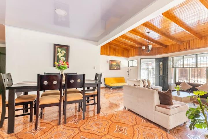 a living room with a table and chairs and a couch at Villa Dreams Irazu in Cartago