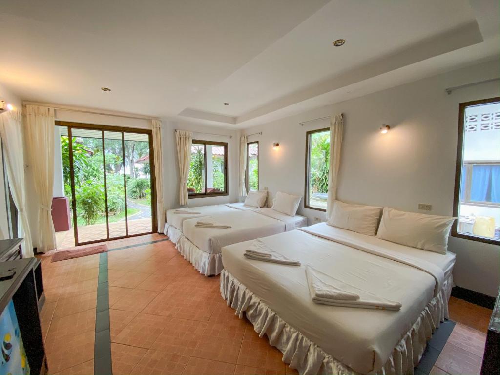 three beds in a room with windows at Samui Honey Backpacker Bungalow in Choeng Mon Beach