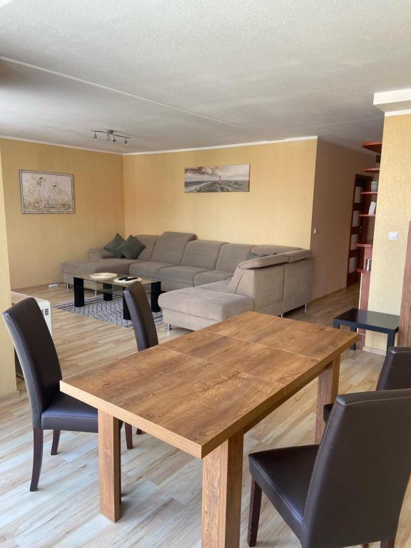 een woonkamer met een tafel en een bank bij Apartament Diego in Polanica-Zdrój