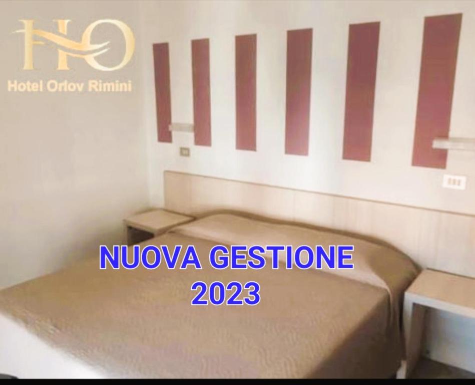 Hotel Orlov Rimini في ريميني: غرفة نوم صغيرة مع سرير في غرفة