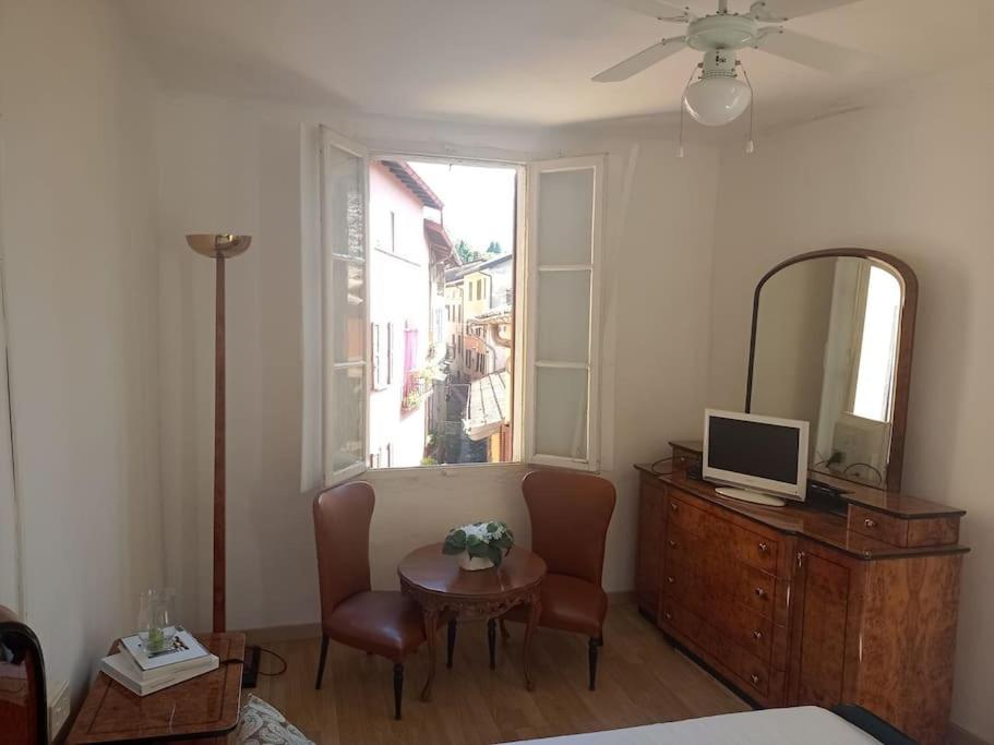 una camera con letto, tavolo e specchio di Ca' del Portico a Valsolda