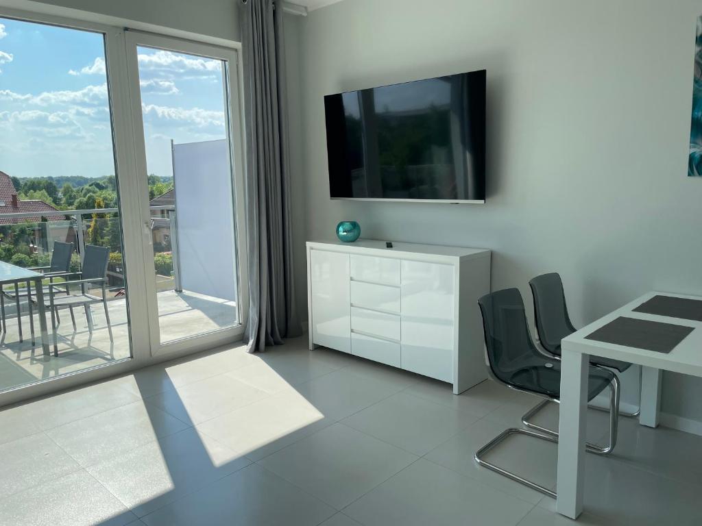 Televízia a/alebo spoločenská miestnosť v ubytovaní Apartamenty AQUA MAZURY