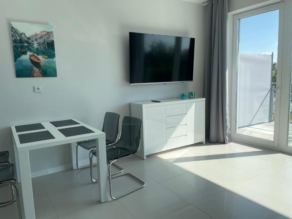 Televízia a/alebo spoločenská miestnosť v ubytovaní Apartamenty AQUA MAZURY