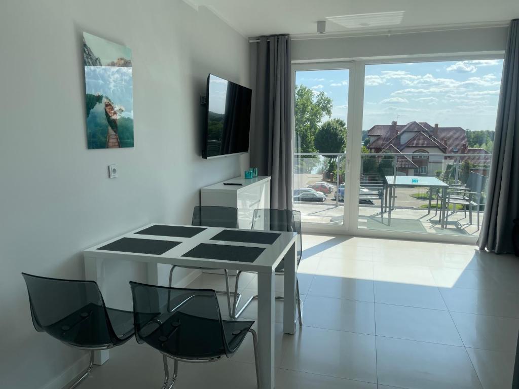 Televízia a/alebo spoločenská miestnosť v ubytovaní Apartamenty AQUA MAZURY