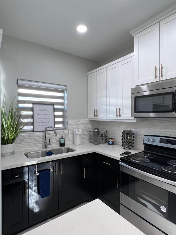 a kitchen with white cabinets and a sink and a stove at Luxurious Modern Apartment #4 in Edinburg