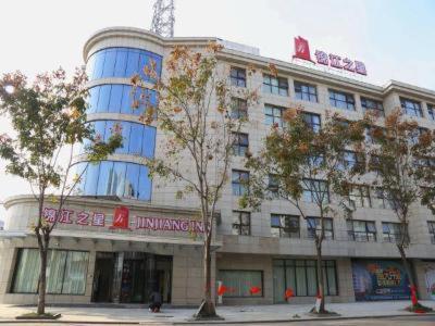 a large building with trees in front of it at Jinjiang Inn Yangzhou Gaoyou East Haichao Road in Gaoyou