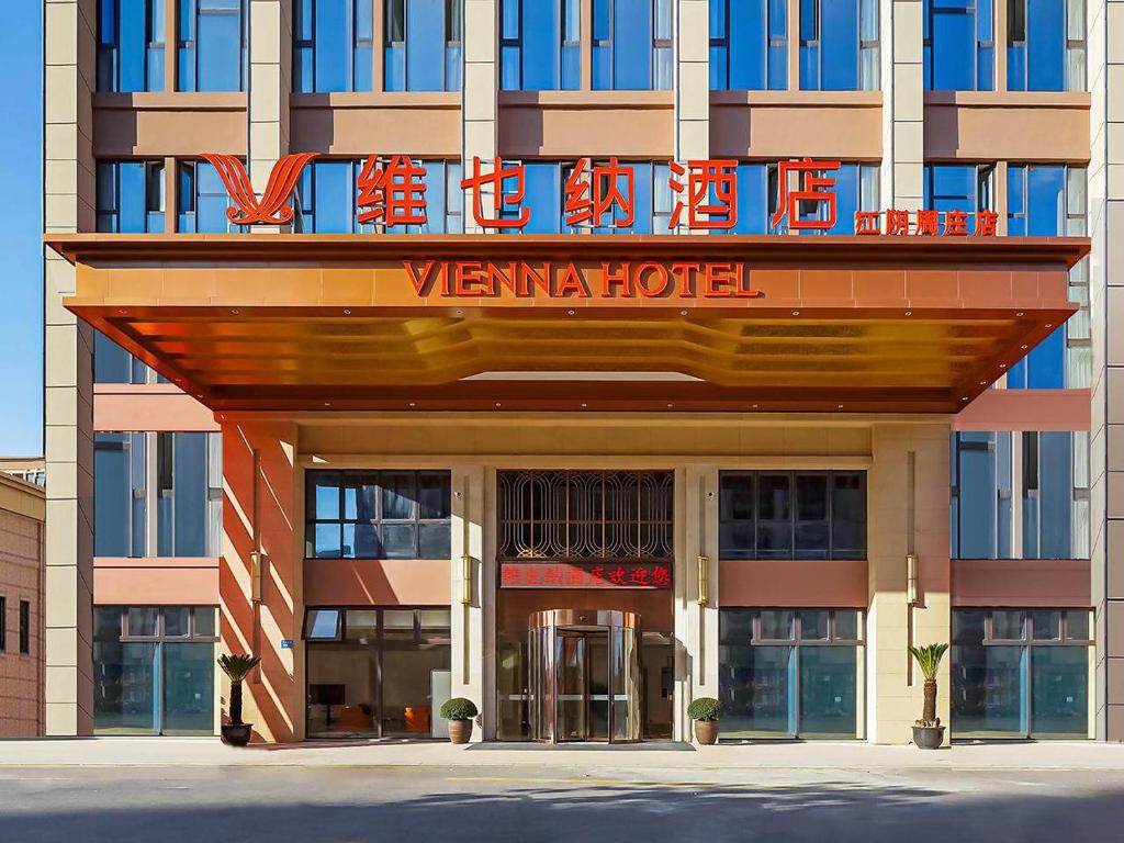 een hotel met een bord aan de voorzijde bij Vienna Hotel Jiangyin Zhouzhuang in Jiangyin