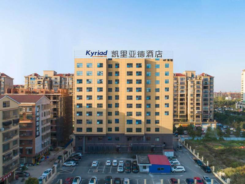 a large building with a parking lot in front of it at Kyriad Marvelous Hotel Yiyang Ziyang in Yiyang