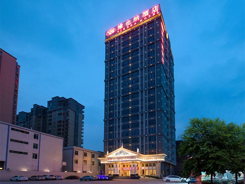 ein hohes Gebäude mit einem Schild darüber in der Unterkunft Vienna Hotel Jieyang Rongjiangxincheng Store in Jieyang