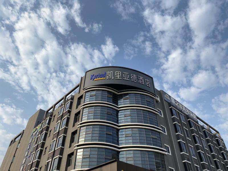 a building with a sign on the top of it at Kyriad Marvelous Hotel Daya Bay BYD Technology Park in Huizhou