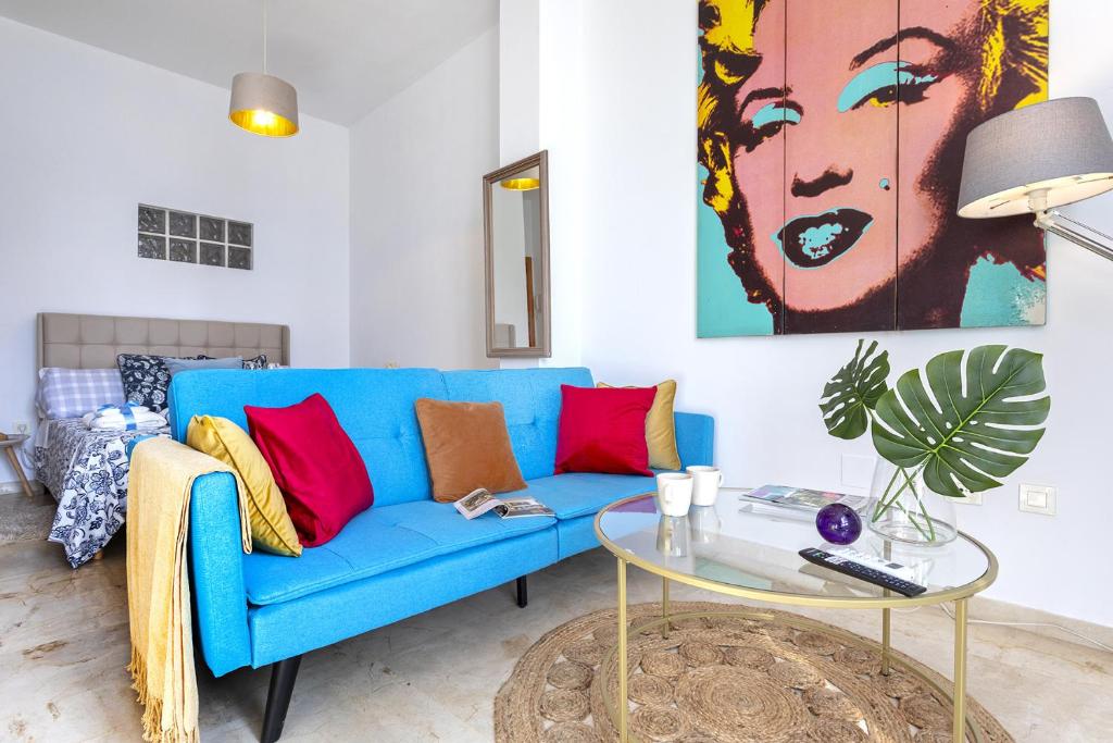 um sofá azul numa sala de estar com uma mesa em -MalagaSunApts-Pop Dream CityCentre em Málaga