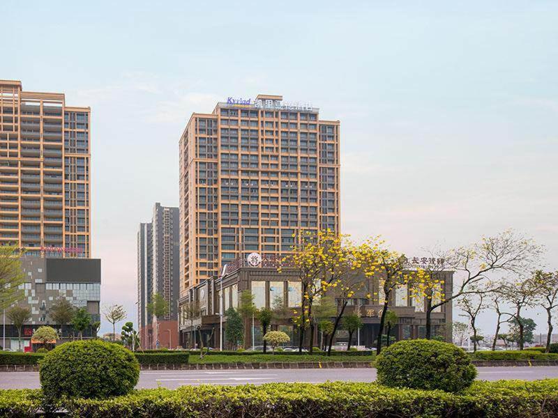 miasto z wysokimi budynkami i ulicą z krzakami w obiekcie Kyriad Marvelous Hotel Foshan Nanzhuang Taobo Avenue w mieście Foshan