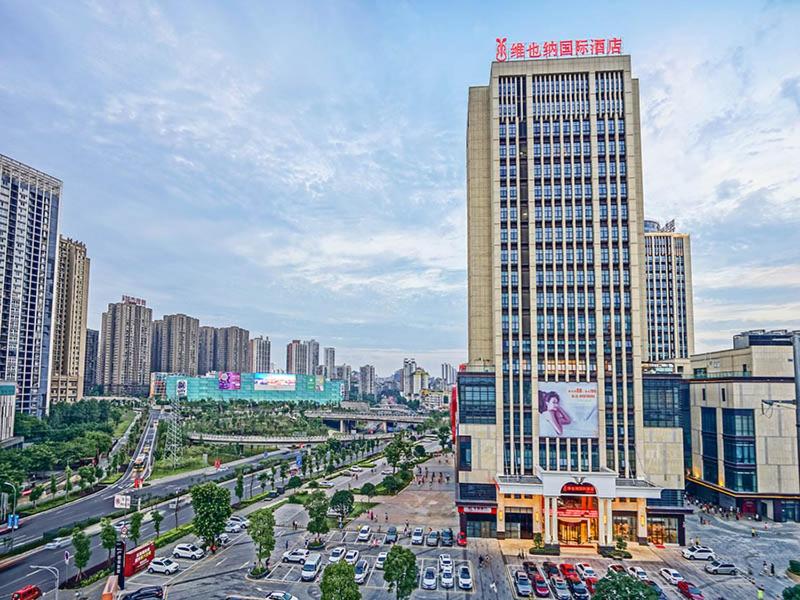 een stad met een hoog gebouw en een straat met auto's bij Vienna International Hotel Chongqing Ranjiaba in Chongqing