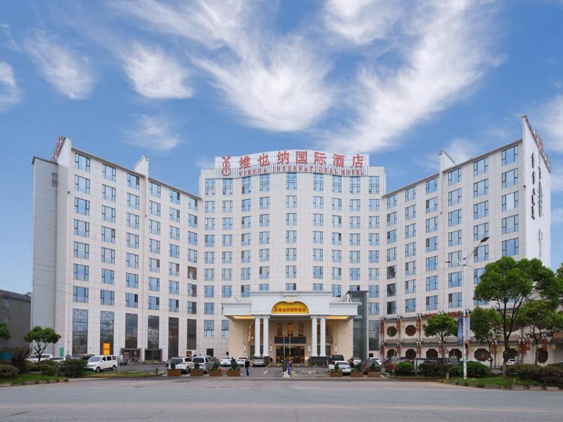um grande edifício branco com um cartaz em Vienna International Hotel Nanchang Qingshan Lake Wanda Plaza em Nanchang