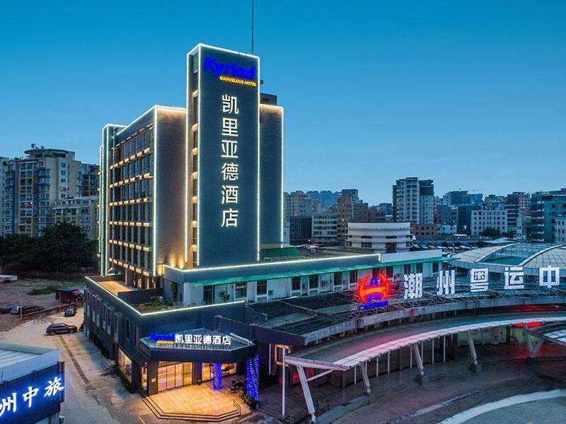 a building with a train station in front of a city at Kyriad Marvelous Hotel Chaozhou Fortune Central in Chaozhou