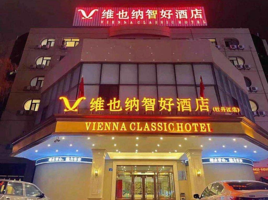 un edificio con una señal delante de él en Vienna Classic Hotel Mudanjiang Railway Station, en Mudanjiang