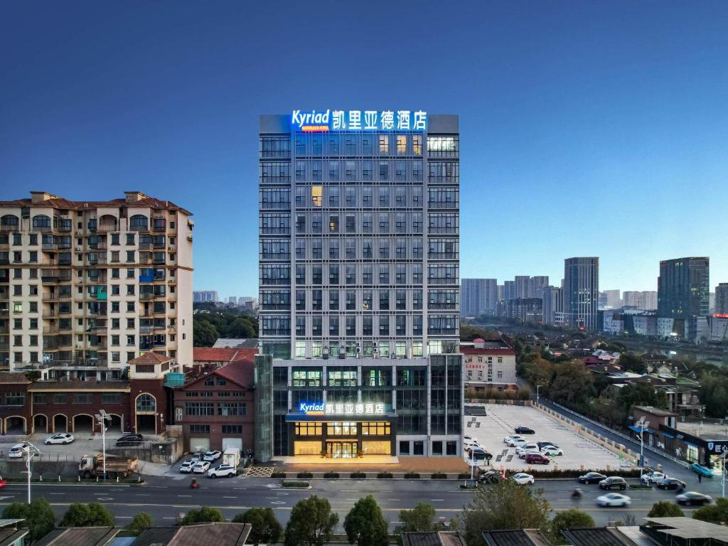 a tall building with a sign on it in a city at Kyriad Marvelous Hotel NanChang Xiang Lake Jinsha Avenue in Nanchang