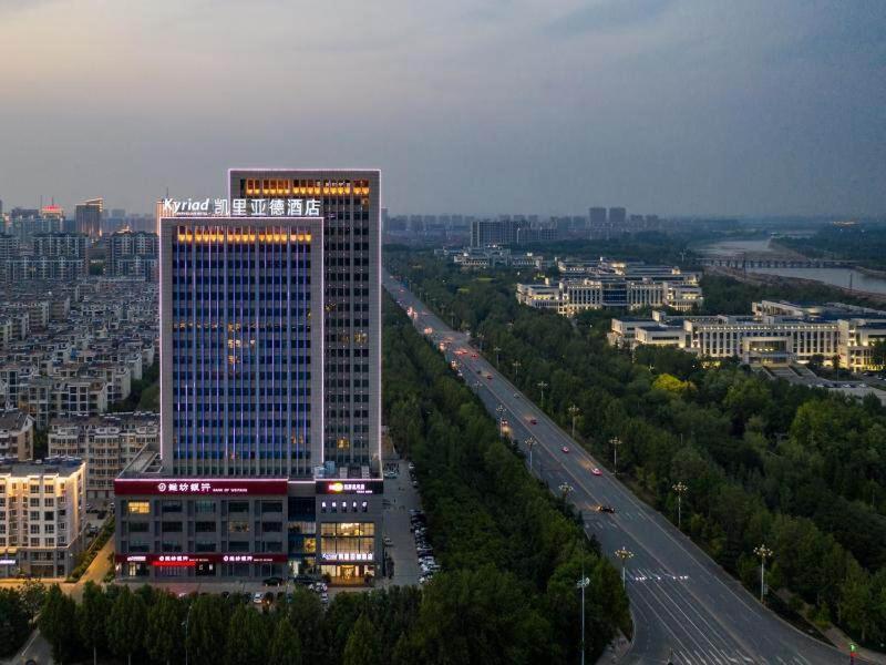 ShouguangにあるKyriad Marvelous Hotel Shouguang Municipal Governmentの高層ビルと高速道路のある市