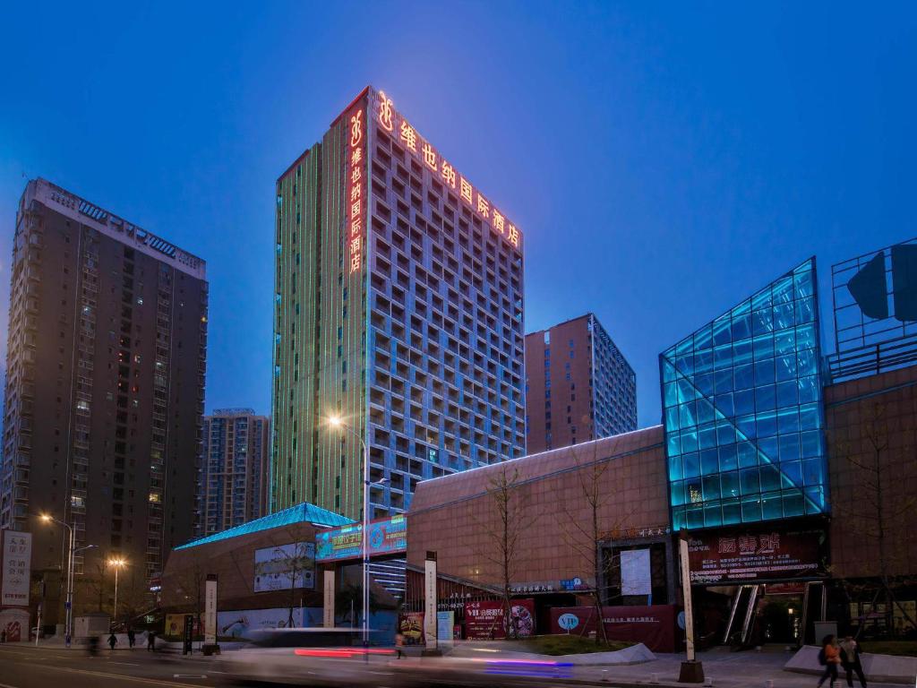 a group of tall buildings in a city at night at Vienna International Hotel Yichang Gezhouba Sanxia Culture Tiandi in Yichang