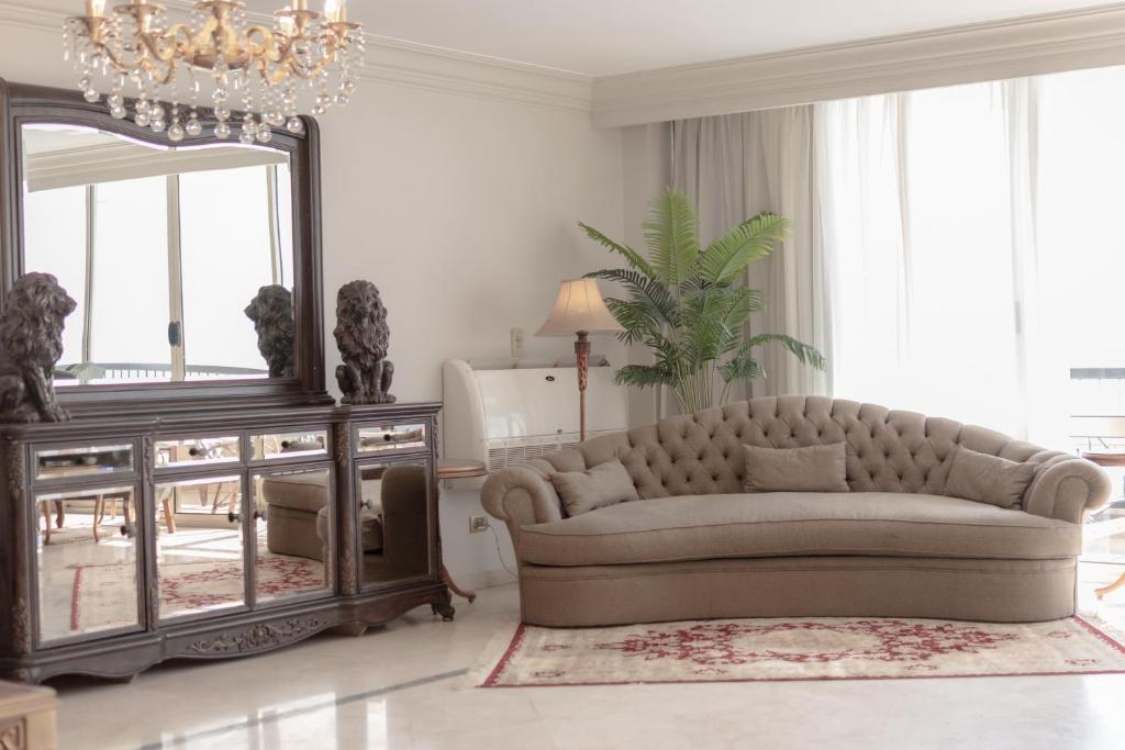 ein Wohnzimmer mit einem Sofa und einem Spiegel in der Unterkunft Cairo, Pyramids and Nile River View Luxury Apartment, Maadi Corniche in Kairo