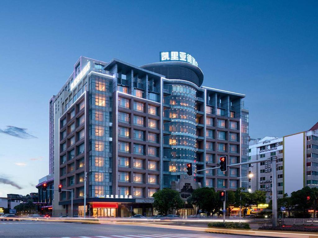 a tall building with lights on in a city at Kyriad Marvelous Hotel Dongguan Municipal Government in Dongguan