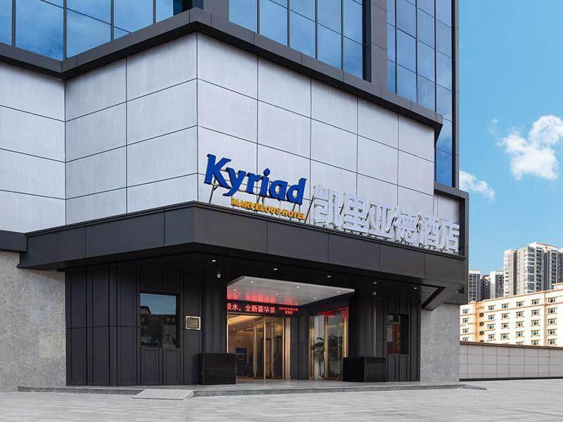 a building with a sign on the side of it at Kyriad Marvelous Hotel Huizhou South Station Danshui YI Center in Huizhou