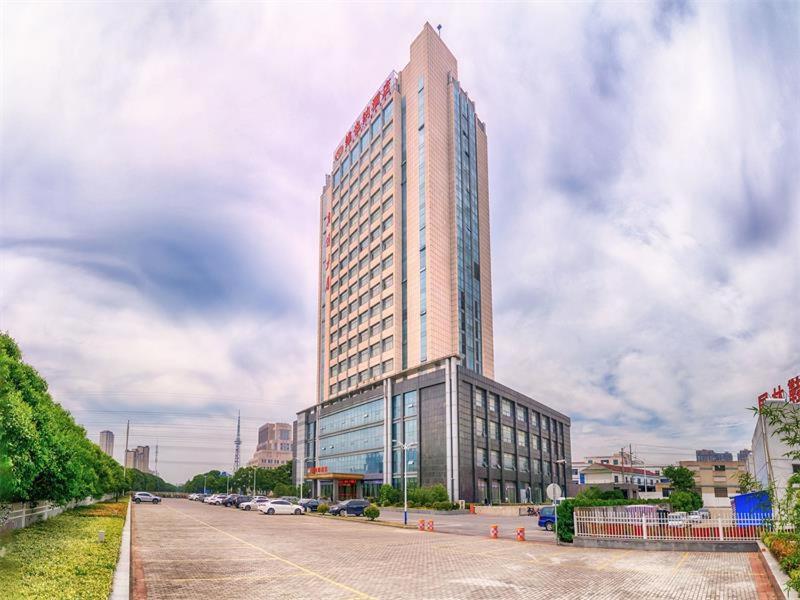 Un palazzo alto con molte finestre su una strada di Vienna Hotel Jiangsu Danyang Railway Station a Danyang