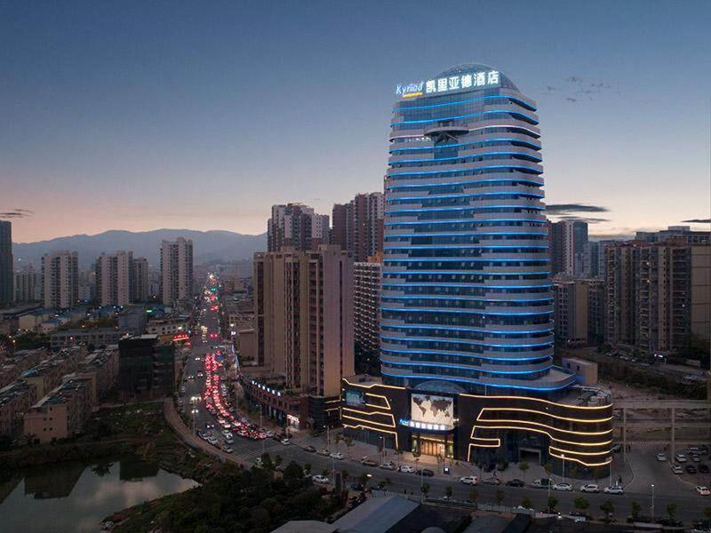 a large building in a city with traffic at Kyriad Marvelous Hotel Heyuan Wanlong City in Heyuan