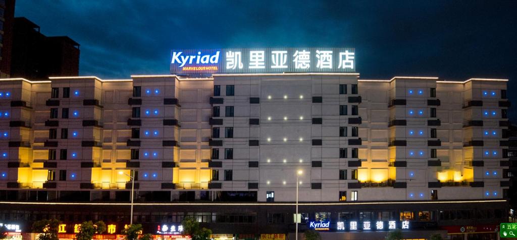 a building with a sign on top of it at night at Kyriad Marvelous Hotel Shantou Railway Station in Shantou