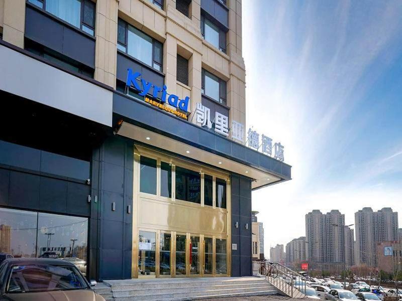 um edifício com um carro estacionado em frente em Kyriad Marvelous Hotel Haerbin West High-Speed Railway Station Wanda em Harbin
