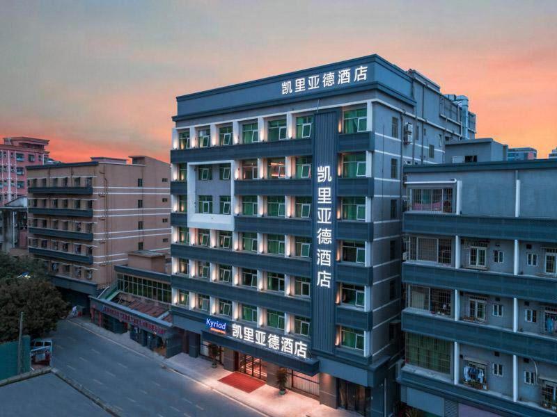 un edificio alto azul con escritura en el costado en Kyriad Marvelous Hotel Shenzhen Guangming Zhenmei Subway Station, en Bao'an
