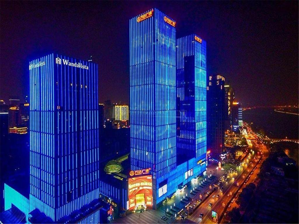 two tall buildings in a city at night at Kyriad Marvelous Hotel Changsha Furong Plaza Railway Station in Changsha