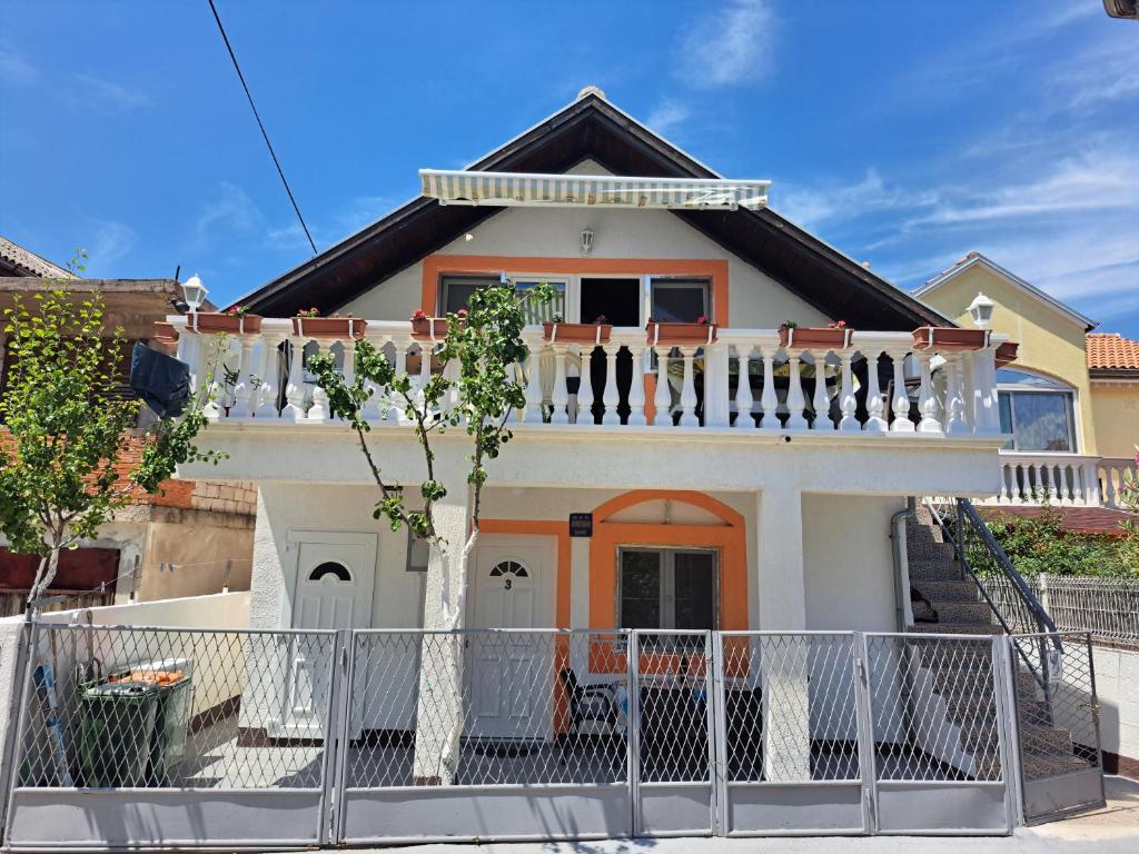 une maison avec un balcon et une clôture dans l'établissement Apartments Ganic, à Tribunj
