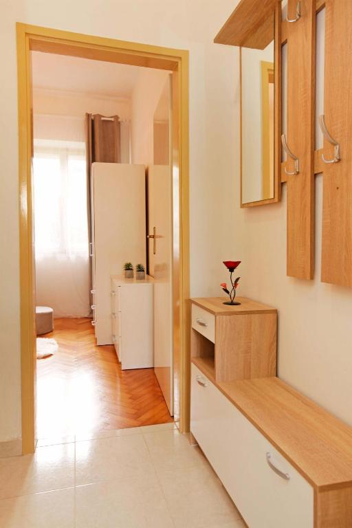 a kitchen with a white refrigerator and a table at Apartman Žuvela in Vela Luka