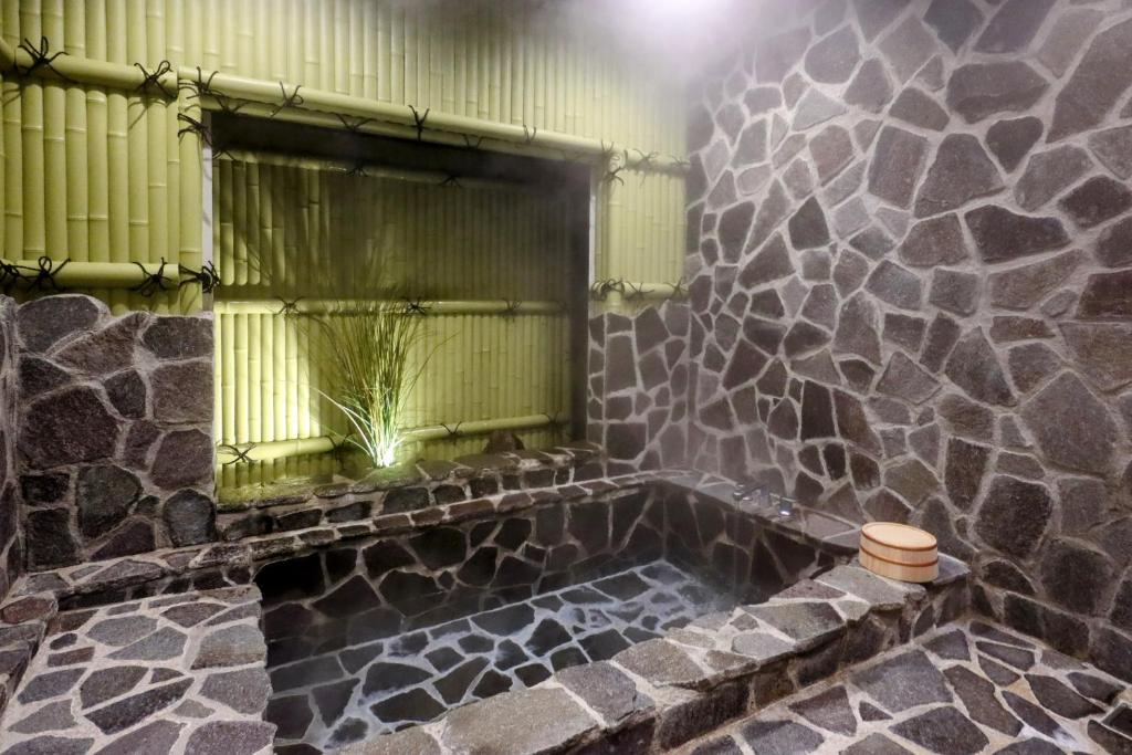 Baño de piedra con bañera y ventana en 1日1組限定Villa Dazaifu 露天風呂付1棟貸し en Dazaifu