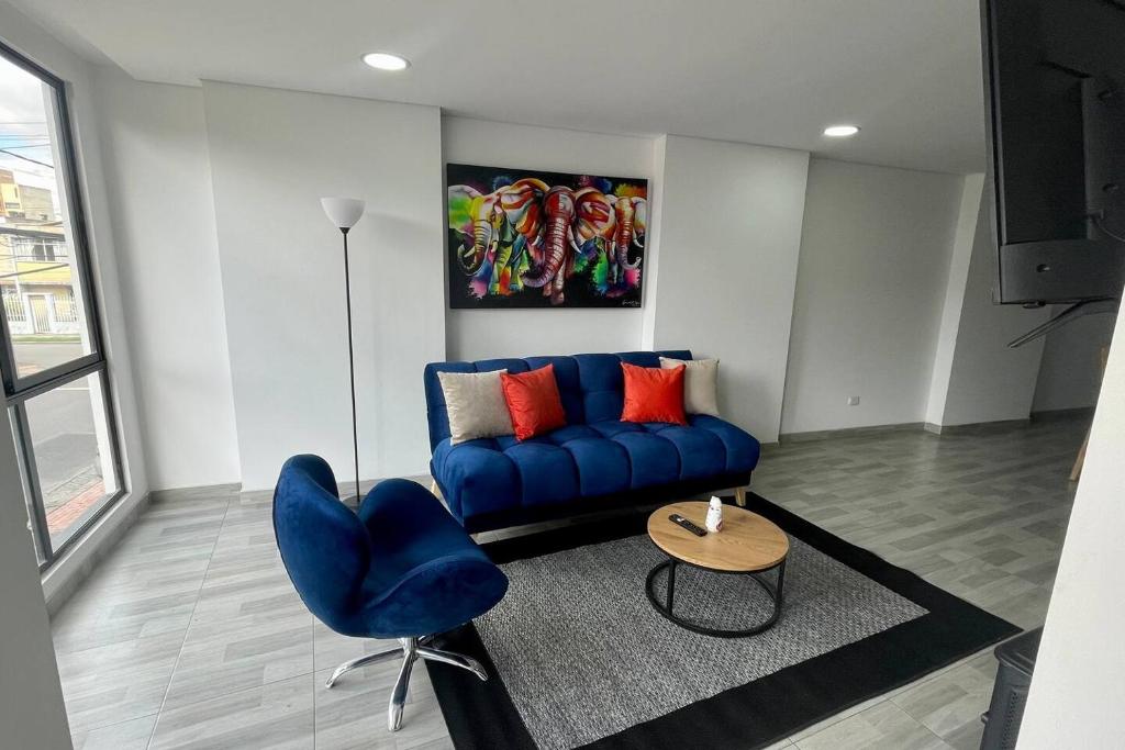 sala de estar con sofá azul y mesa en Luxury Corferias-USA Embassy & Airport Condominium, en Bogotá
