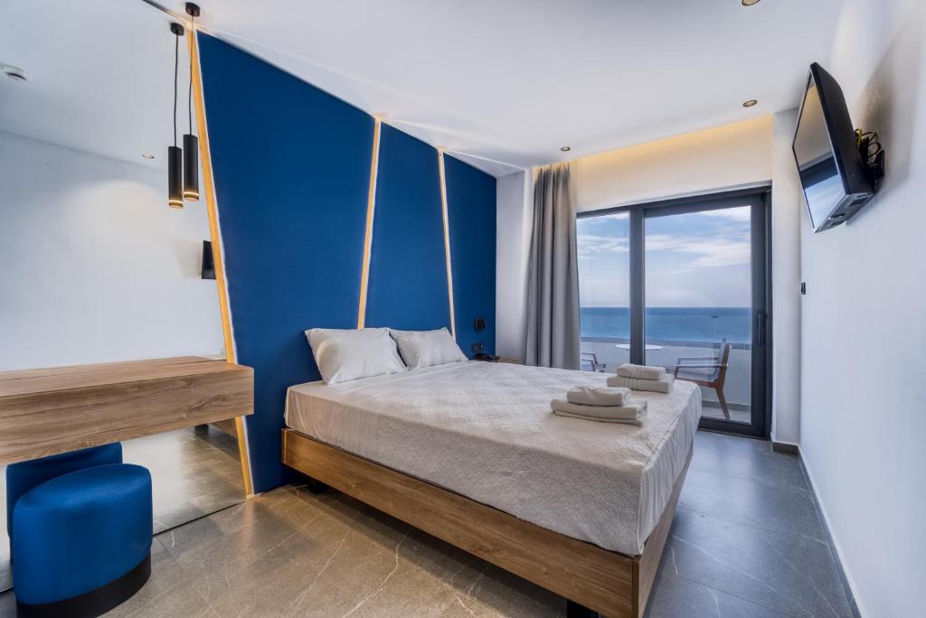 Schlafzimmer mit einem Bett mit blauer Wand in der Unterkunft Island Sea Side Hotel - Adults Only in Rhodos (Stadt)