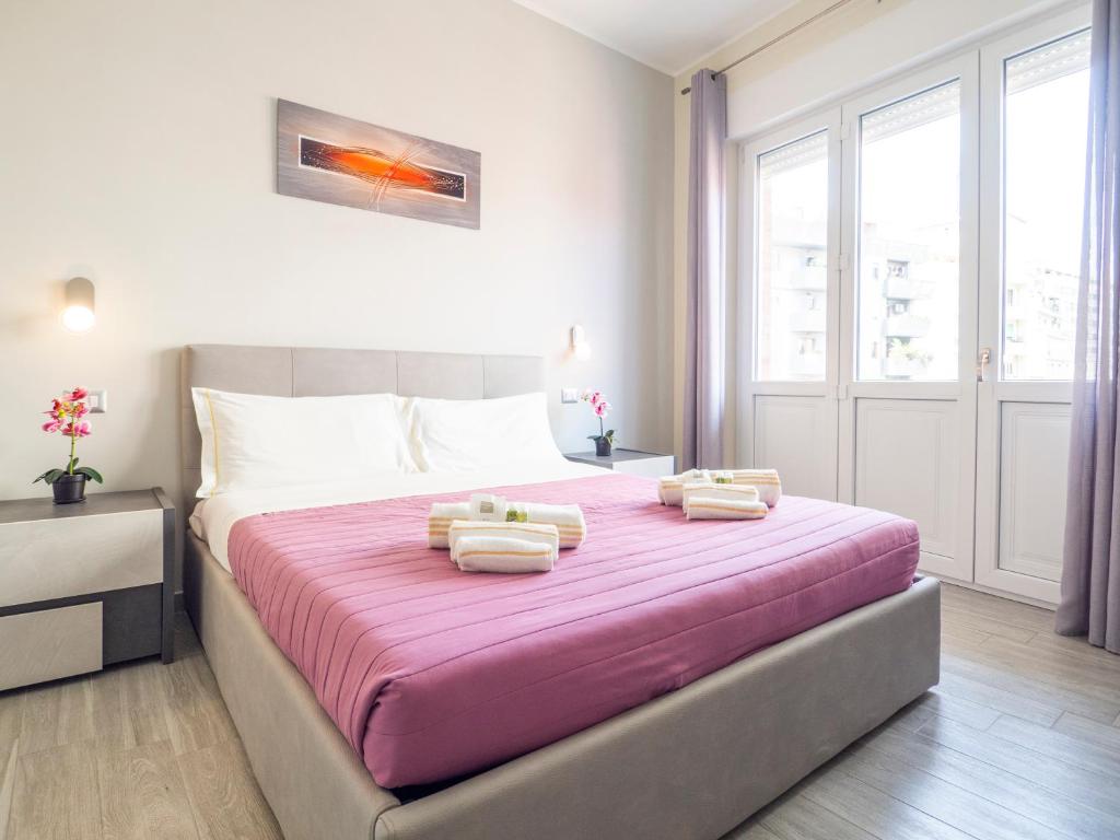1 dormitorio con 1 cama grande y toallas. en Sweet Dreams - MORADA, en Cagliari