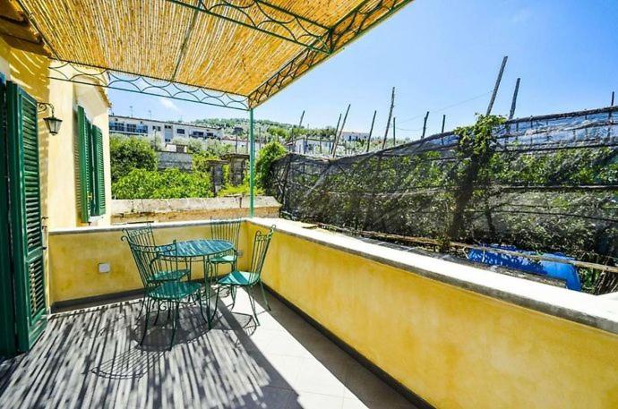 patio con mesa y sillas en el balcón en Casa Tiberio, en Massa Lubrense