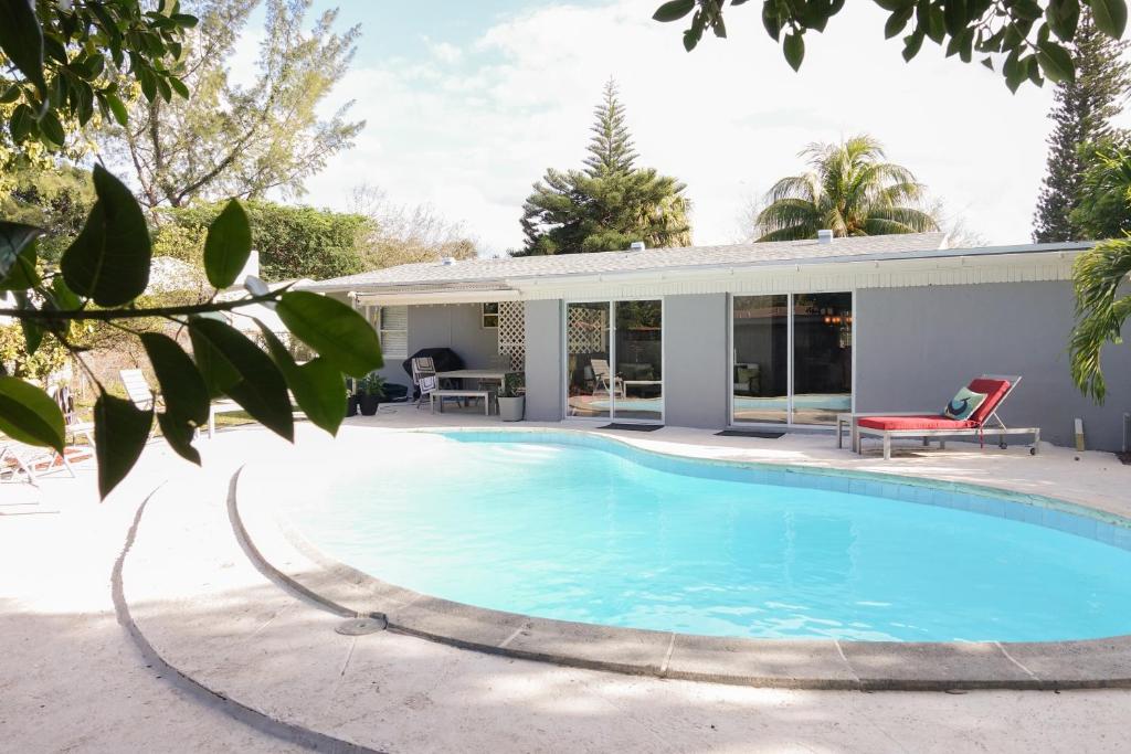 a swimming pool in front of a house at Miami Beach Villa with Sparkling Pool! Sleeps 10+! in North Miami Beach