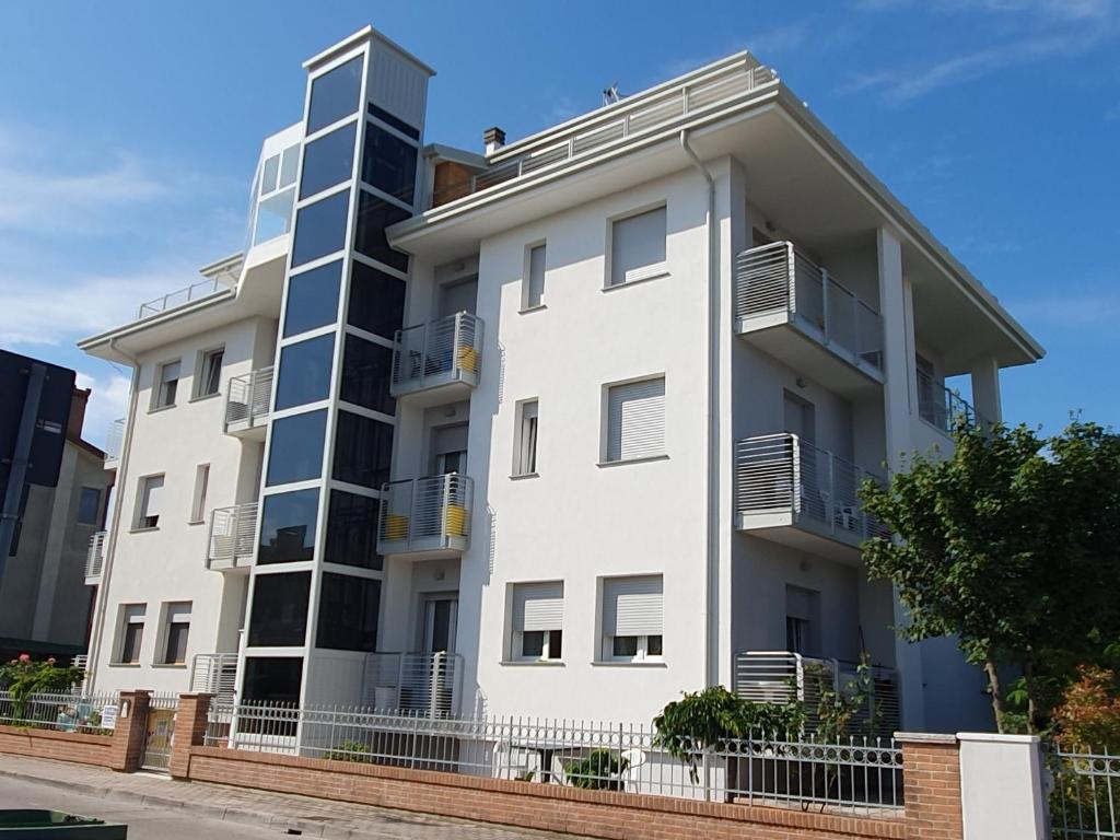ein weißes Apartmenthaus mit Balkon darauf in der Unterkunft Appartamenti Lino in Caorle